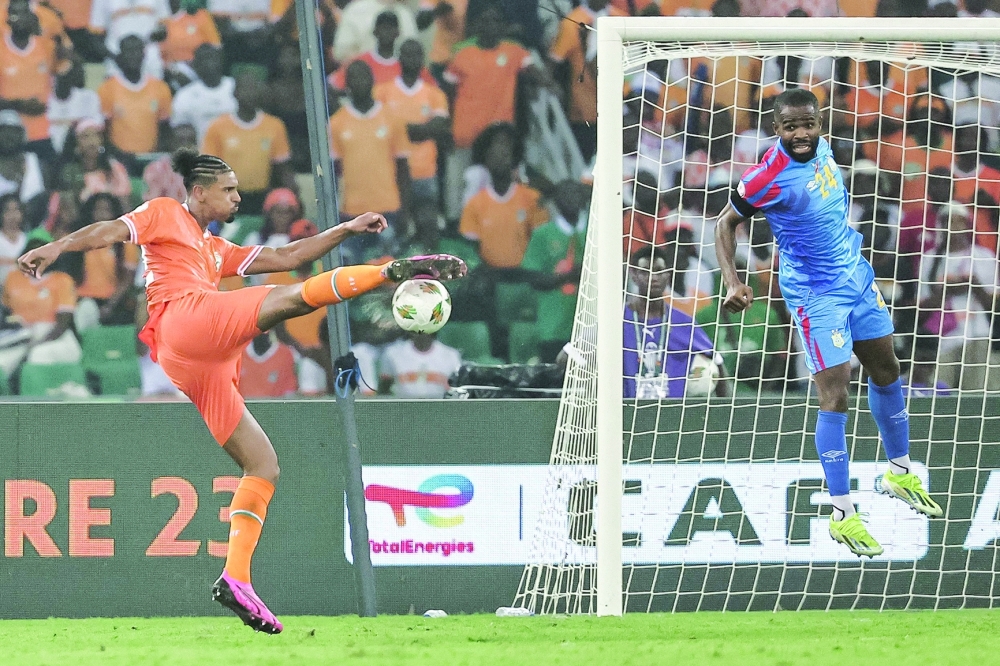 Ivory Coast's forward #22 Sebastien Haller (L) kicks to score his team's first goal during the Africa Cup of Nations (CAN) 2024 semifinal football match between Ivory Coast and Democratic Repuplic of Congo at Alassane Ouattara Olympic Stadium in Ebimpe, Abidjan on February 7, 2024.
