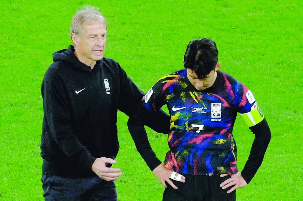 South Korea's German coach Jurgen Klinsmann speaks to midfielder #07 Son Heung-min after losing to Jordan at the end of the Qatar 2023 AFC Asian Cup semifinal football match between Jordan and South Korea at the Ahmad bin Ali Stadium in Al Rayyan, west of Doha on February 6, 2024.
