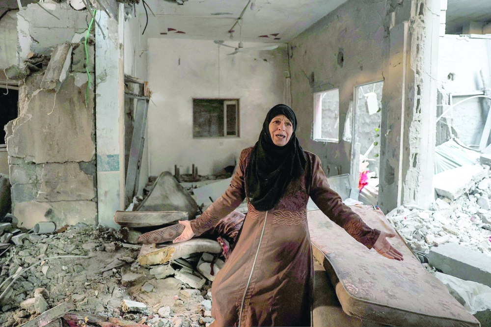 A Palestinian woman cries as she inspects a heavily damaged apartment following Israeli bombardment on Rafah in the southern Gaza Strip. - AFP


