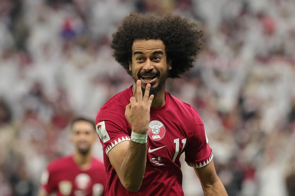 Qatar's forward #11 Akram Afif celebrates after scoring his third goal from a penalty shot during the AFC Qatar 2023 Asian Cup final football match