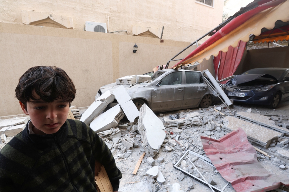 A Palestinian boy stands at the site of an Israeli strike on a house in Rafah in the southern Gaza Strip. - Reuters
