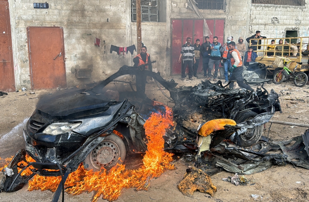 A firefighter extinguishes a burning car hit by an Israeli strike in Rafah in the southern Gaza Strip. - Reuters 