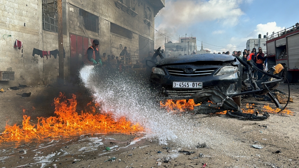A firefighter extinguishes a burning car hit by an Israeli strike in Rafah in the southern Gaza Strip