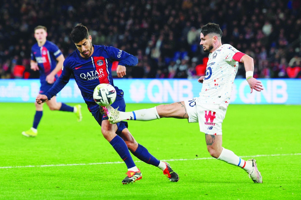 Remy Cabella (R) stretches top control the ball ahead of Marco Asensio (L). — AFP

