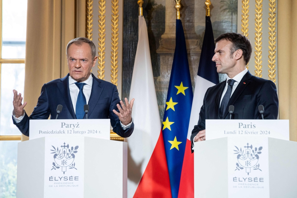 Polish PM Donald Tusk (L) gestures as he speaks to the media next to French President Emmanuel Macron (R) as they deliver a statement as part of their meeting at Elysee Palace, in Paris. — AFP 