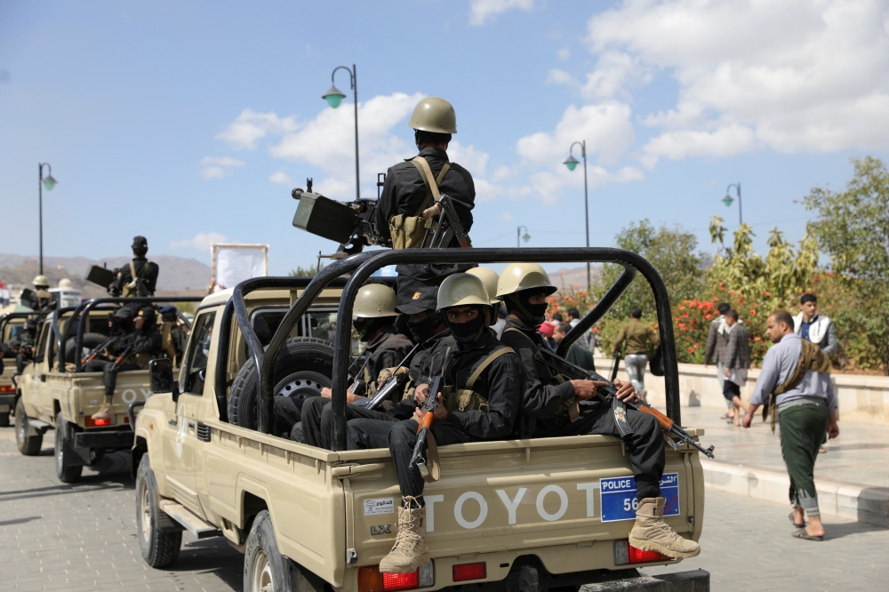Yemeni policemen ride on the back of a patrol pick-up trucks during the funeral of fighters killed in U.S.-led strikes, in Sanaa on February 10. — Reuters 