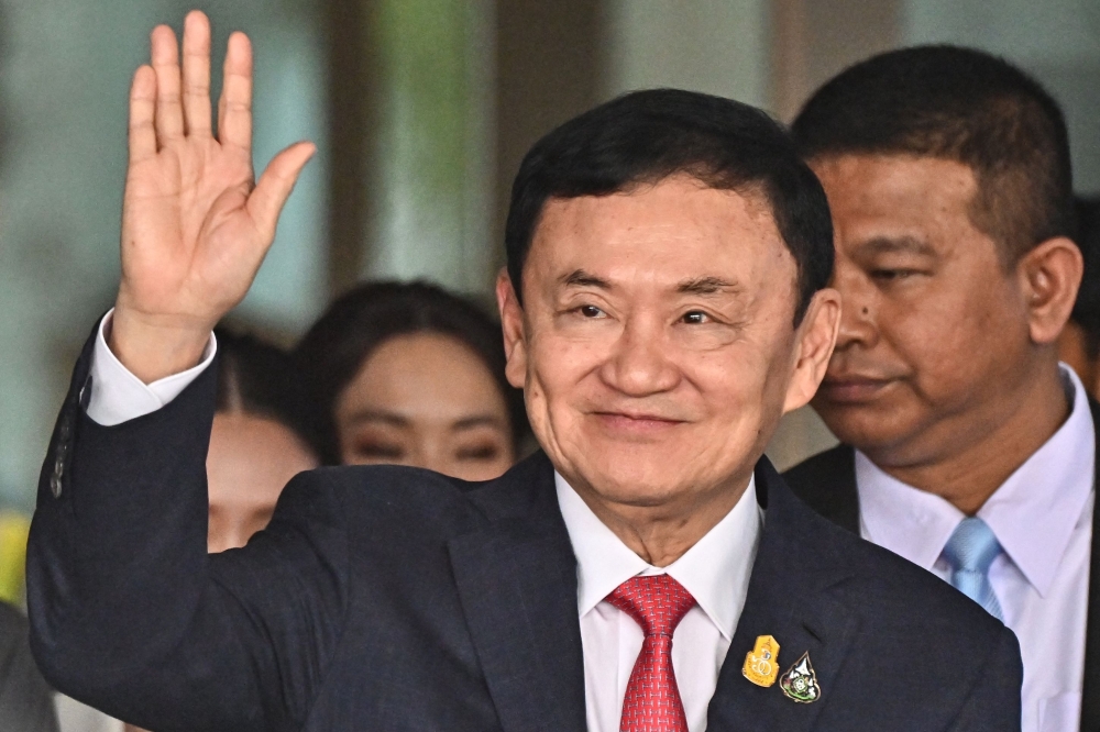 Former Thai Prime Minister Thaksin Shinawatra greets his supporters at Bangkok's Don Mueang airport. — AFP file photo 