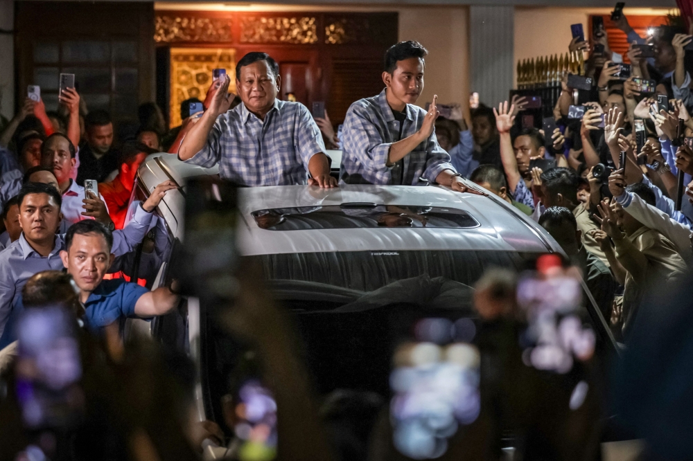 Presidential candidate and Indonesia's Defence Minister Prabowo Subianto (L) react to supporters after polls closed in the country's presidential and legislative elections in Jakarta. — AFP 