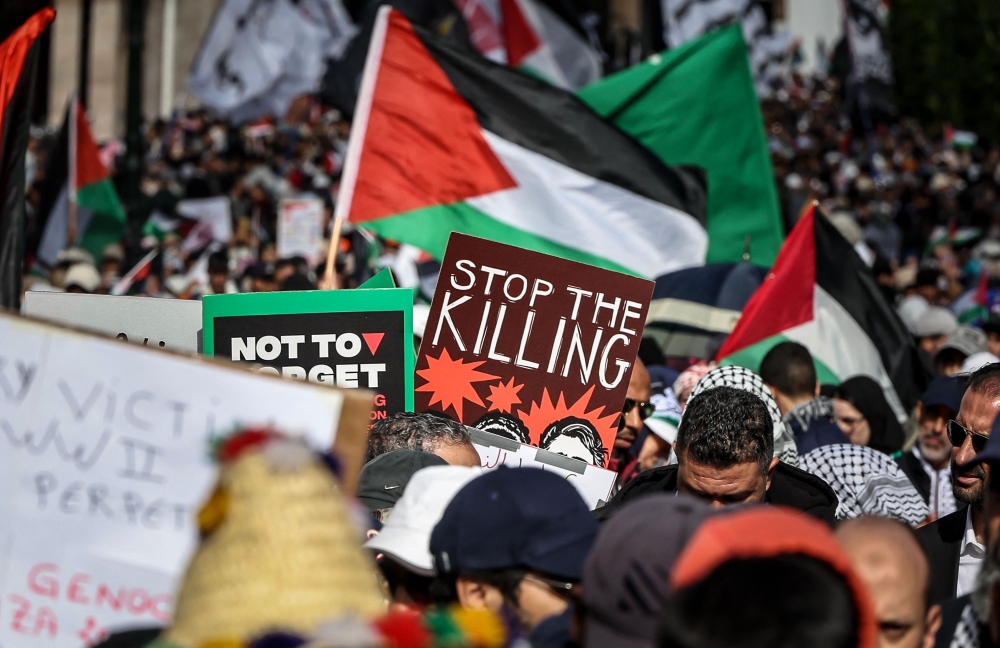 Protesters lift placards and flags of Palestine during a demonstration in Rabat in solidarity with Palestinians. — AFP file photo 