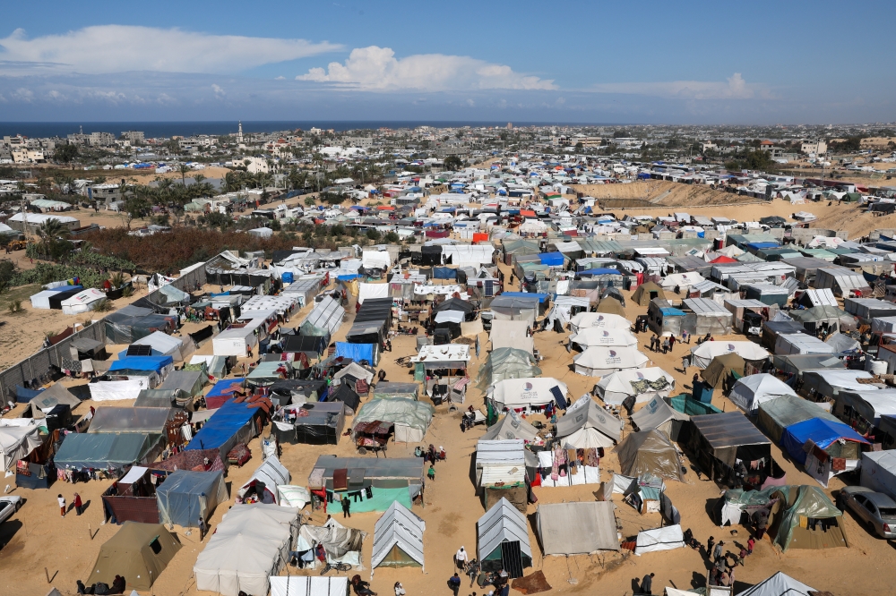 Displaced Palestinians, who fled their houses due to Israeli strikes, take shelter in a tent camp