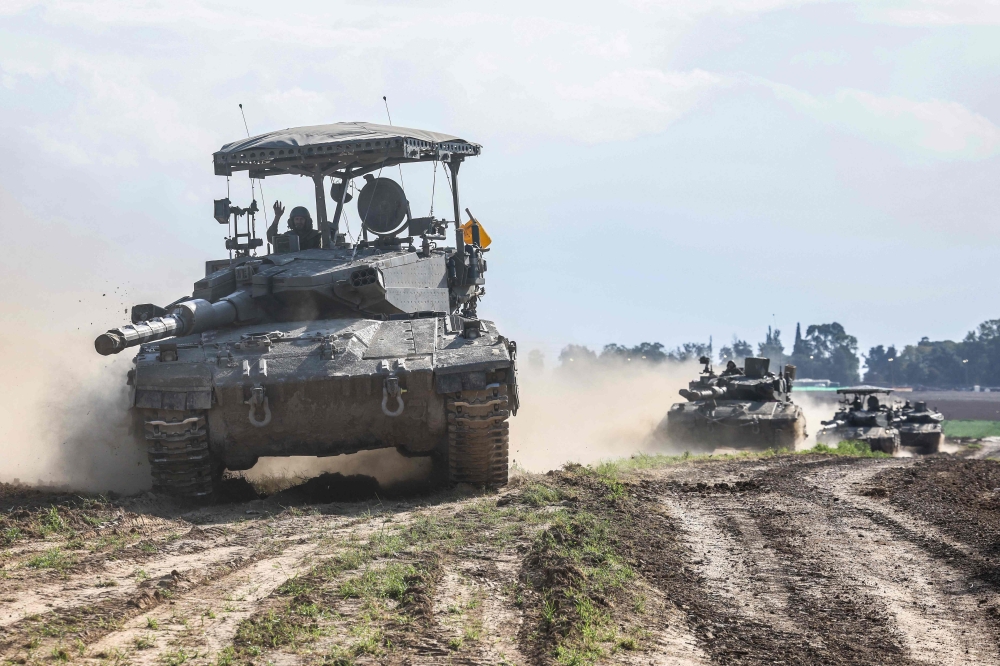 Israeli tanks roll near the border with the Gaza Strip on February 14, 2024, amid ongoing fighting between Israel and the Palestinian Hamas militant group.