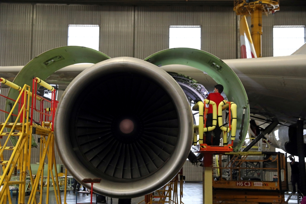 An IAG Iberia's worker inspects an engine after transforming an Airbus 330 passenger aircraft into a cargo one in Madrid._REUTERS