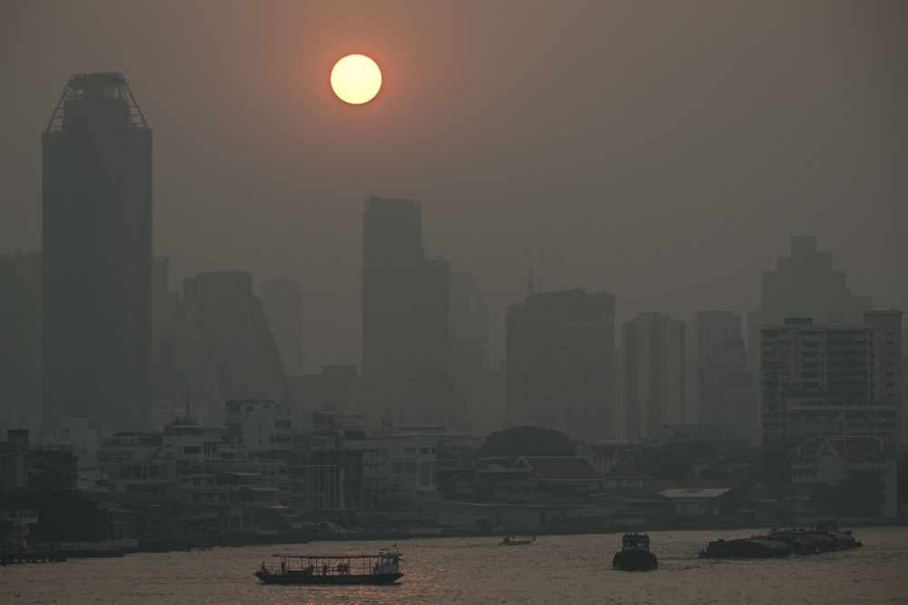  Commuter boats cross the Chao Praya River amid high air pollution levels in Bangkok. — AFP 