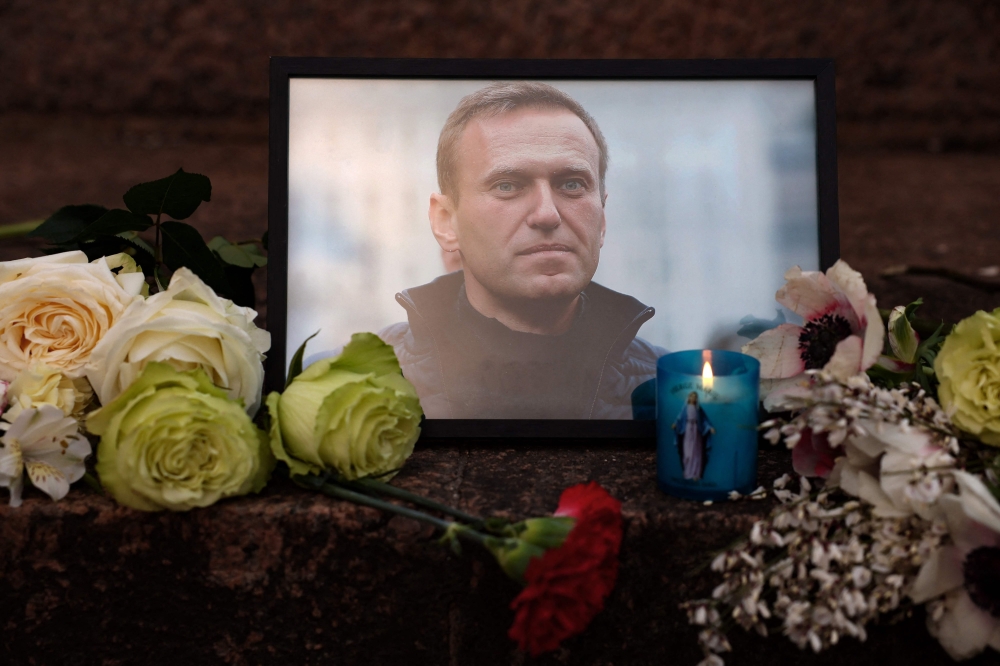 A portrait of Alexei Navalny, candles and flowers are left at a memorial in Paris on after the announcement that the Kremlin's most prominent critic had died in an Arctic prison