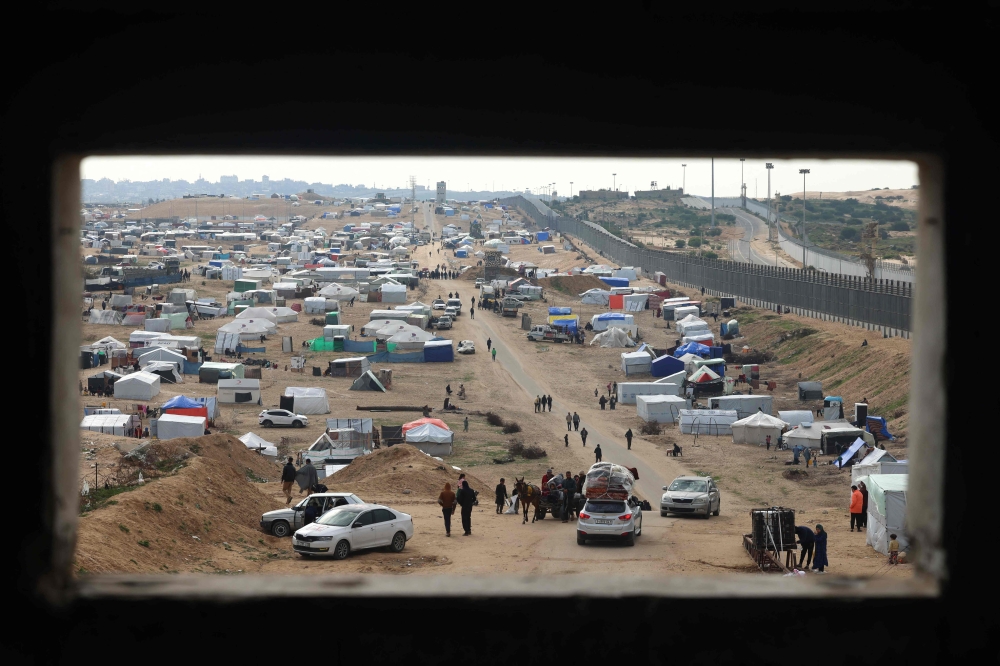 Displaced Palestinians camp near the border fence between Gaza and Egypt