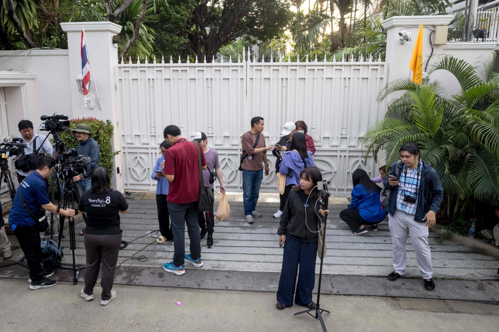 Members of the media gather outside the family compound of Thailand's former prime minister Thaksin Shinawatra following his release from a police hospital in Bangkok. — AFP 