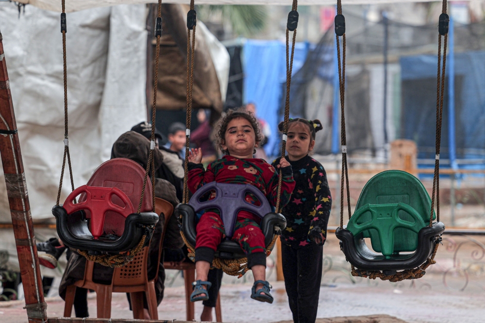  A child rides a swing in Rafah in the southern Gaza Strip