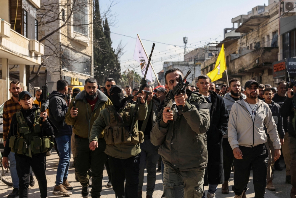 Palestinian gunmen lead the procession as mourners walk in the funeral of Aref Marwan who was killed by the Israeli army, in the West Bank. — AFP 