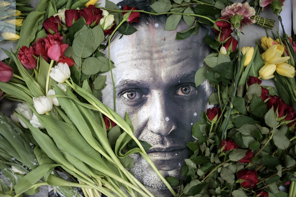 Flowers are seen placed around a portrait of late Russian opposition leader Alexei Navalny at a makeshift memorial in front of the former Russian consulate in Frankfurt