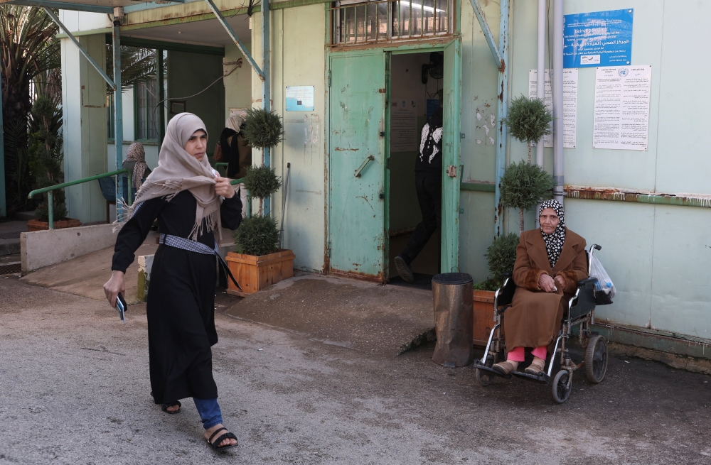 A woman walks past a polyclinic run by UNRWA near Mar Elias Palestinian refugee camp in Beirut
