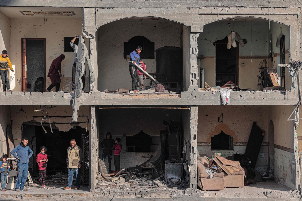 Palestinians check the debris at a building on Thursday, following overnight Israeli air strikes in Rafah