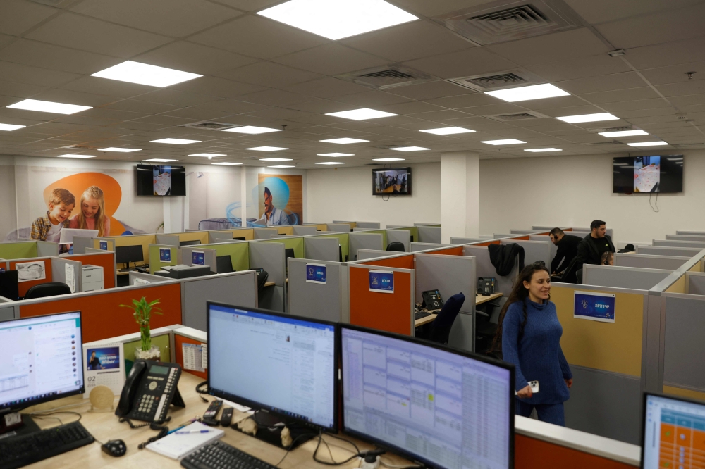 Employees work inside the offices of the Bezeq telecoms firm in the northern Israeli city of Kiryat Shmona near the border with Lebanon on February 22, 2024. 