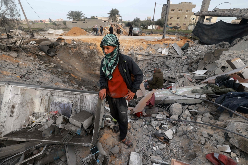 A young boy stands amid the destruction following overnight Israeli bombardment in Rafah on Friday. — AFP