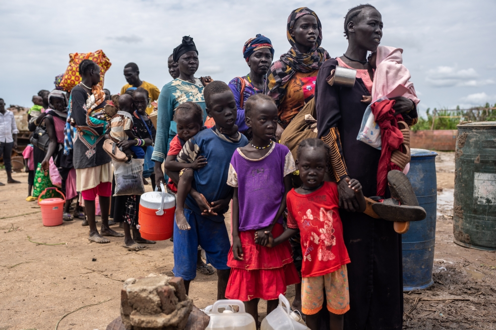 Refugees that fled fighting in Sudan queue to board a barge in Renk, South Sudan, on Aug. 27, 2023. (Joao Silva/The New York Times)