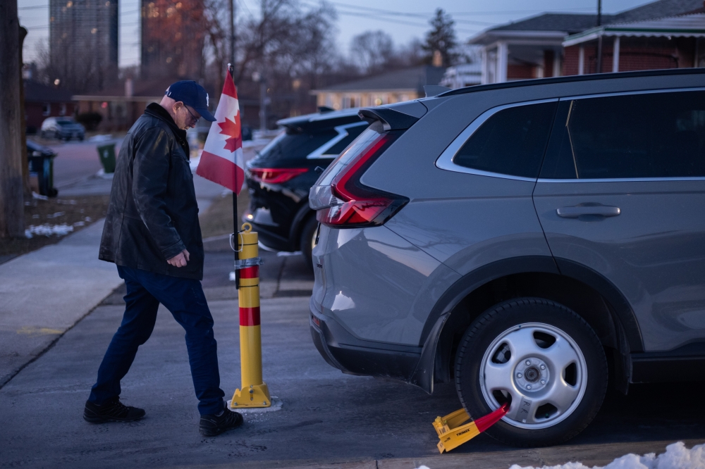 Dennis Wilson, whose theft prevention measures now include a bollard, wheel and steering wheel locks, and four Apple AirTags after his previous two cars were stolen, in Toronto, Feb. 20, 2024. (Ian Willms for The New York Times)