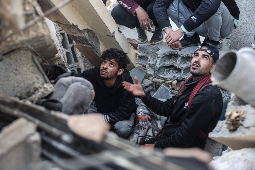 Palestinians search the rubble of their house destroyed in an overnight Israeli air strike in east Khan Yunis. — AFP 