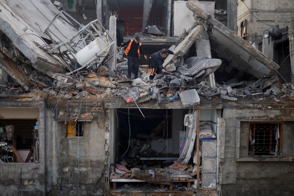 Palestinians inspect the site of an Israeli strike on a house, in Rafah. — Reuters 