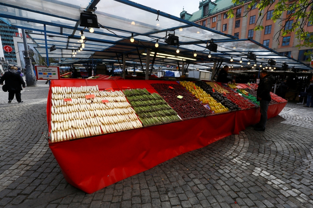Man sells vegetables at Kungsgatan market next to the Drottninggatan in Stockholm, Sweden. — Reuters