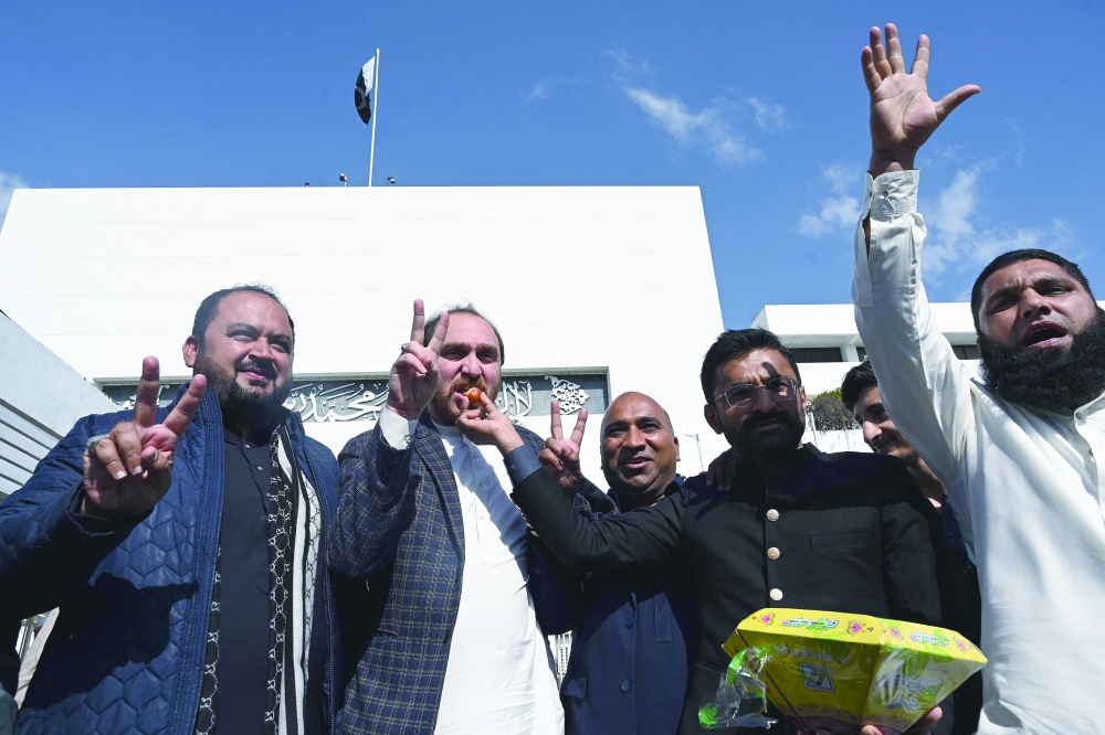 Supporters of the Pakistan Muslim League Nawaz (PMLN) party celebrate after Shehbaz Sharif elected as Pakistan's new prime minister, outside the Parliament House in Islamabad. — AFP 