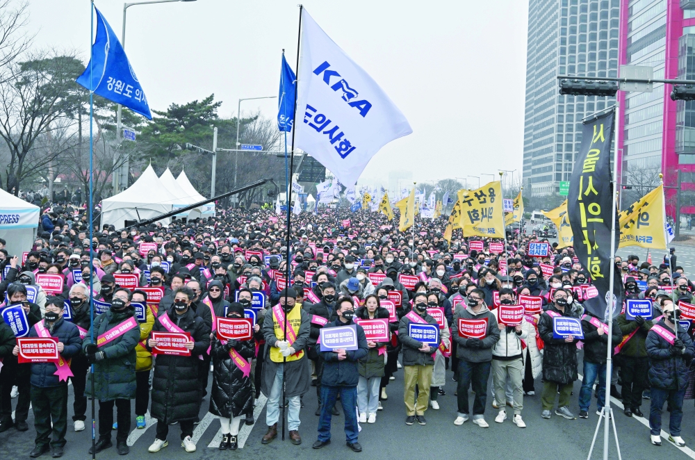 Doctors hold placards during a rally against the government plans, in Seoul. — AFP 