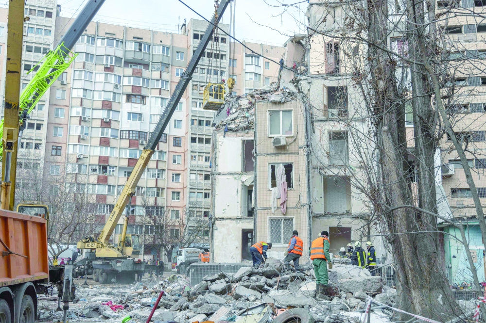 Rescuers clear debris in a multi-story building heavily damaged following a drone strike, in Odesa. — AFP 