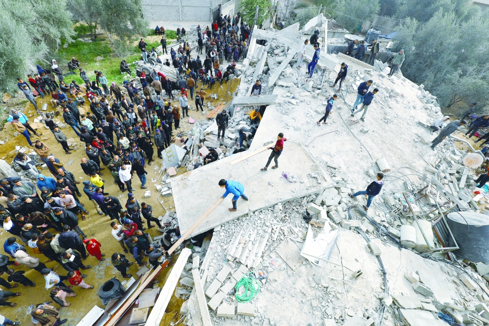 Palestinians inspect the damage following an Israeli airstrike, in Rafah. — Reuters 