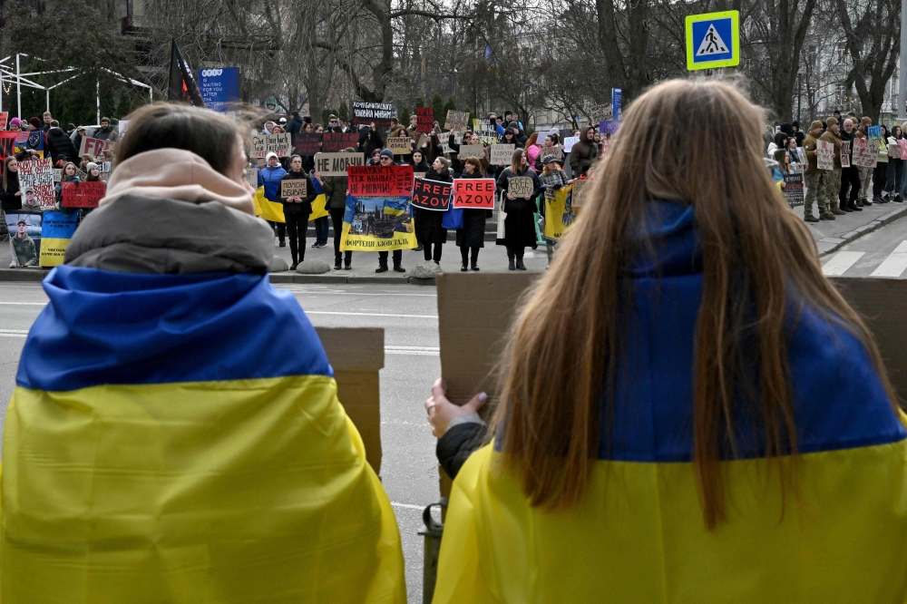Relatives and friends of Ukrainian prisoners of war from the Azov Brigade and sub-units hold placards during a rally in Kyiv. — AFP 