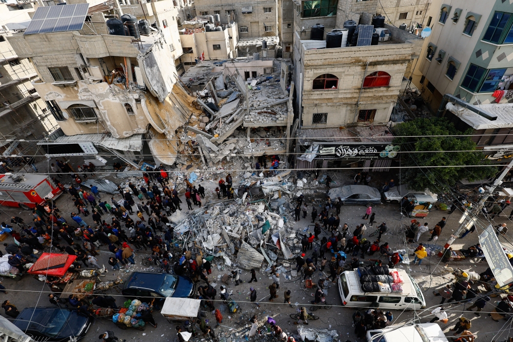 Palestinians gather at the site of an Israeli strike, in Rafah. — Reuters 