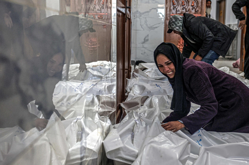 A relative of Palestinians killed when the al-Faqawi family home was hit during overnight Israeli bombardment, mourns over their bodies at the European hospital morgue in Khan Yunis 
