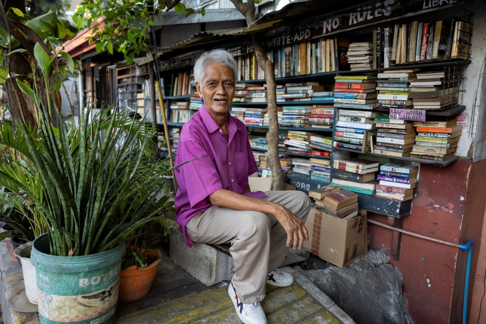 Hernando Guanlao, also known as Mang Nanie, 72, poses in front of his communal library at his home in Makati, Metro Manila, Philippines, February 7, 2024. REUTERS/Eloisa Lopez

