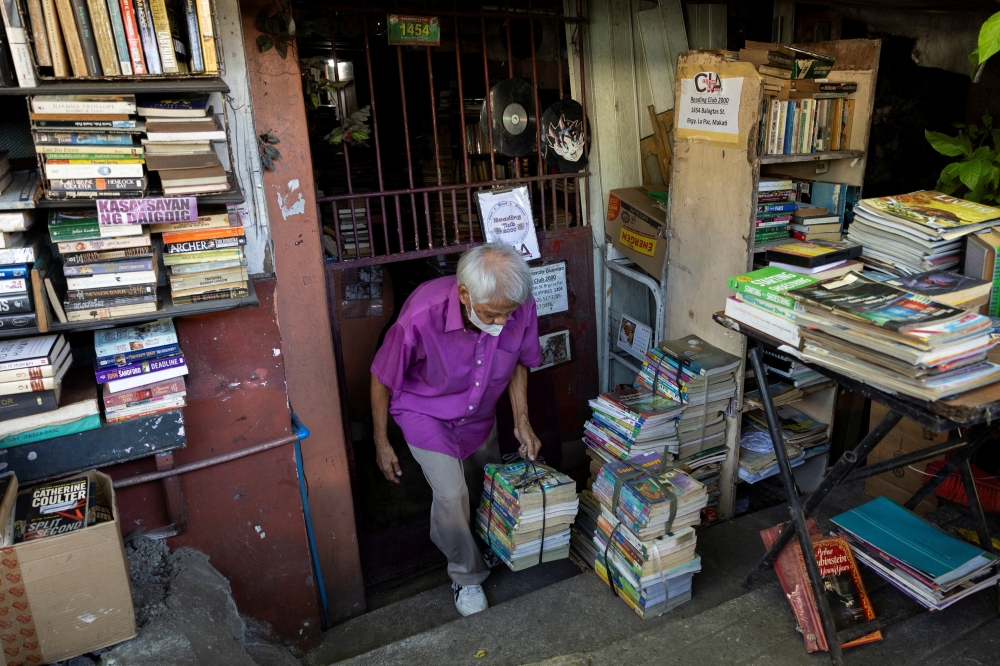 Hernando Guanlao, also known as Mang Nanie, 72, carries donated books at his communal library in Makati, Metro Manila, Philippines, February 7, 2024. REUTERS/Eloisa Lopez

