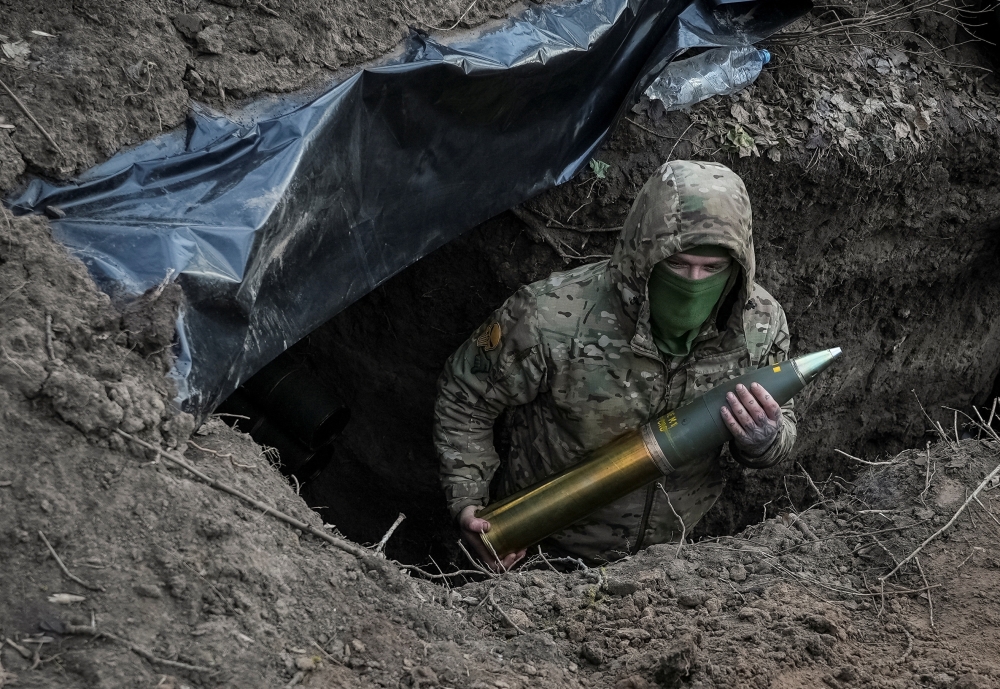 A Ukrainian serviceman holds an artillery shell at a position in a frontline, near the town of Kreminna, Ukraine. — Reuters 