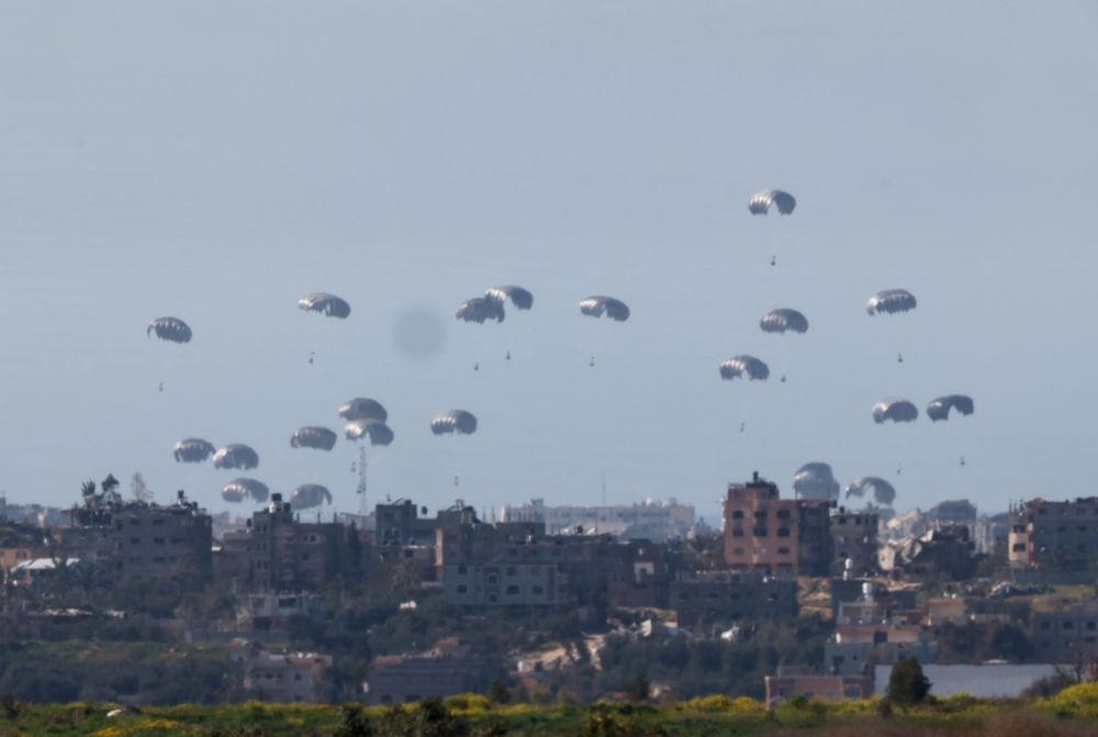 Packages fall towards Gaza, after being dropped from a military aircraft, amid the ongoing conflict between Israel and the Palestinian group Hamas, as seen from Israel's border with Gaza in southern Israel March 5, 2024. REUTERS/Amir Cohen
