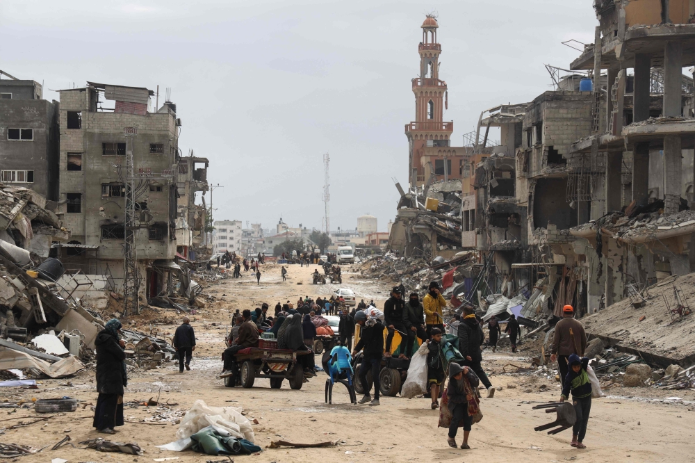 Palestinians carry or transport on carts some personal belongings, as they flee Khan Yunis in the southern Gaza Strip on March 7, 2024