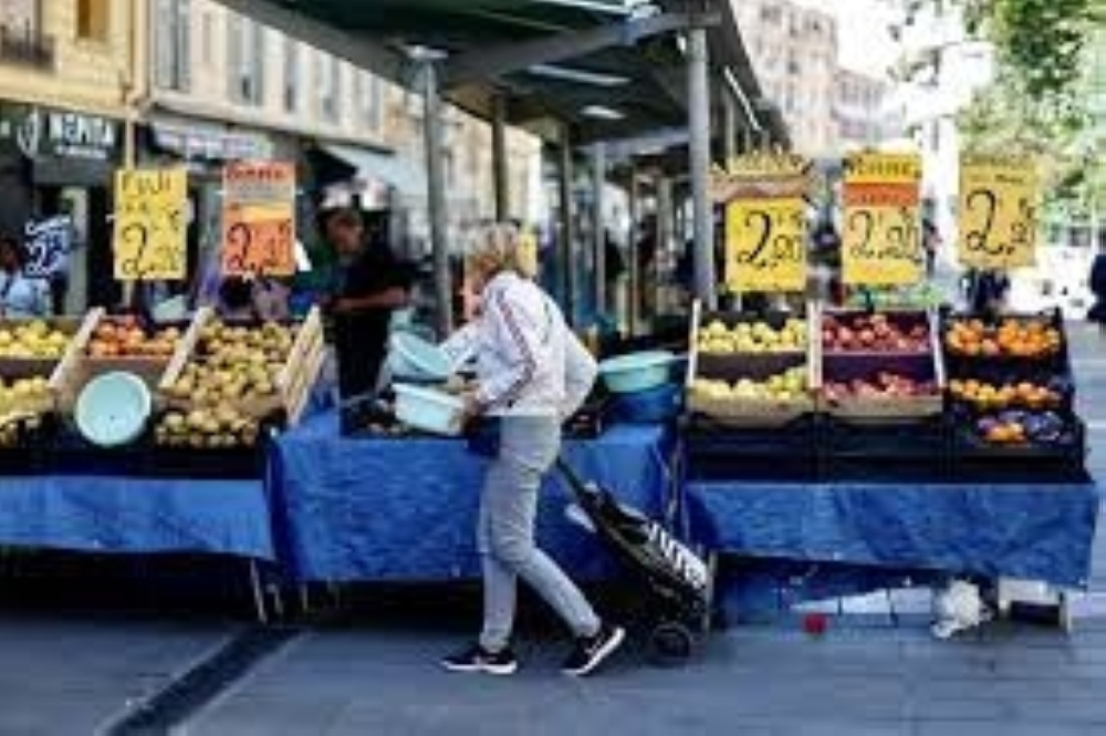 Price tags are seen on fruits as a woman shops at a local market in Nice, France REUTERS