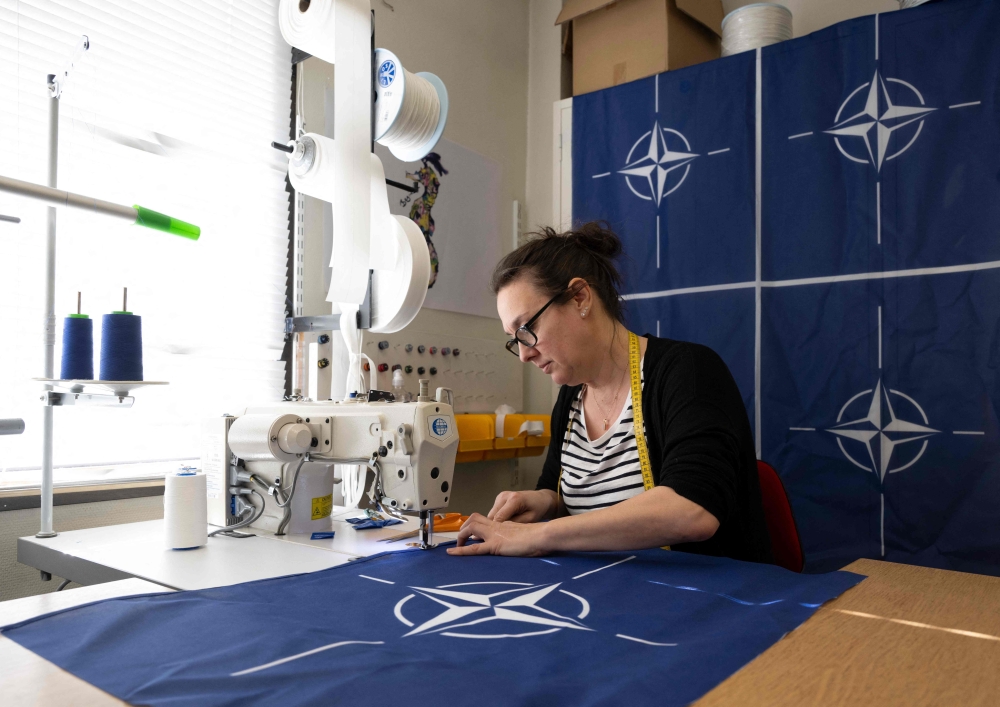 Seamstress Tove Lycke is seen at work with new NATO flags, at the flag manufacturer Flagghuset in Akersberga, outside Stockholm, Sweden, on Thursday. — AFP