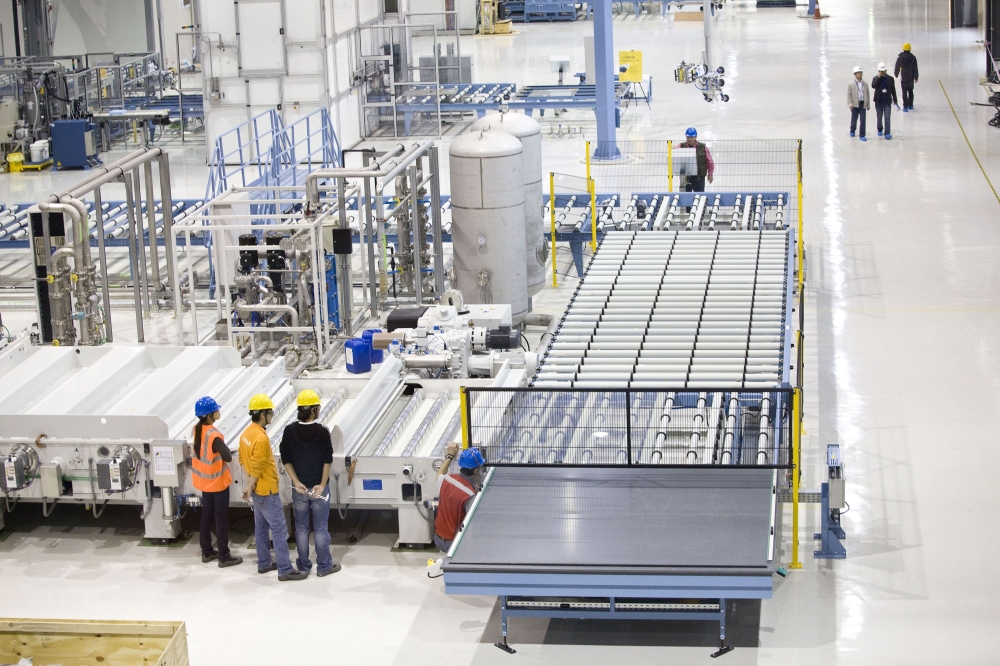 Workers operate an experimental production line for solar panels, built-in 2010 by Applied Materials in Xi’an, China 