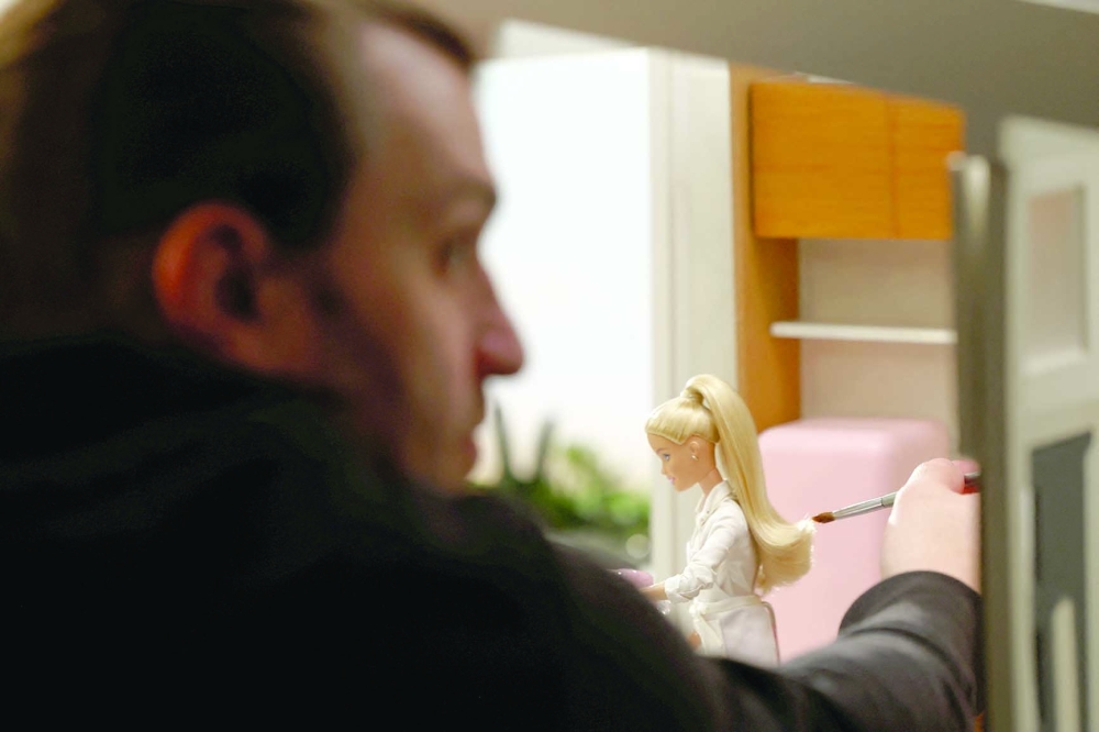 Jason Tidwell, Director of Photography, adjusts the hair of a Barbie doll on a set at Mattel Design Center in El Segundo, California, U.S., February 22, 2024.