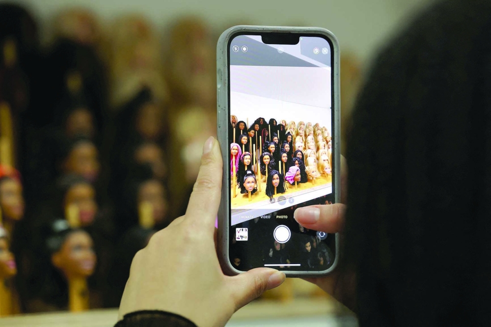 A person takes a photo of Barbie doll heads at Mattel Design Center in El Segundo, California, U.S., February 22, 2024.