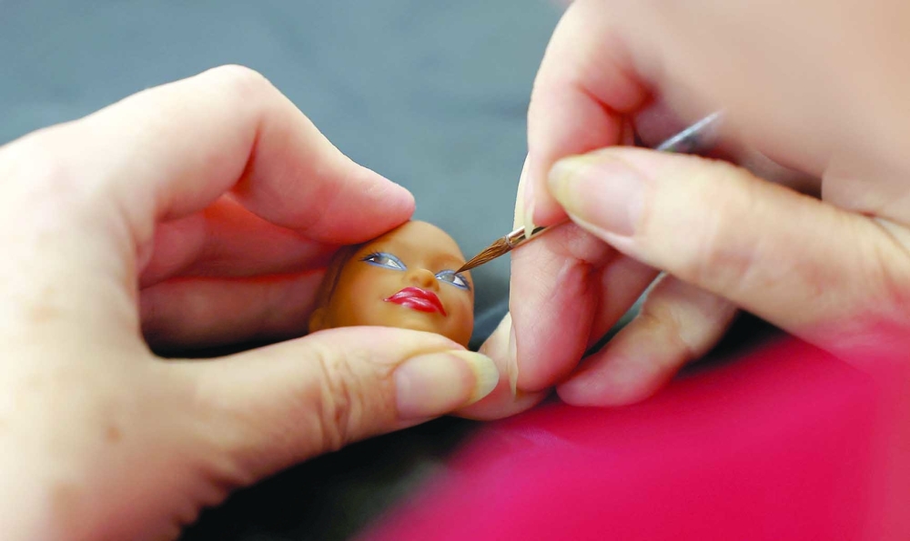 Sasha Stoyan Lopez, Key Lead Face Designer, applies paint on a Barbie doll head at Mattel Design Center in El Segundo, California, U.S., February 22, 2024.
